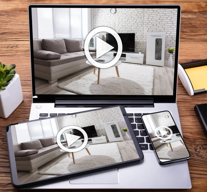 A tablet and laptop showing real estate videos