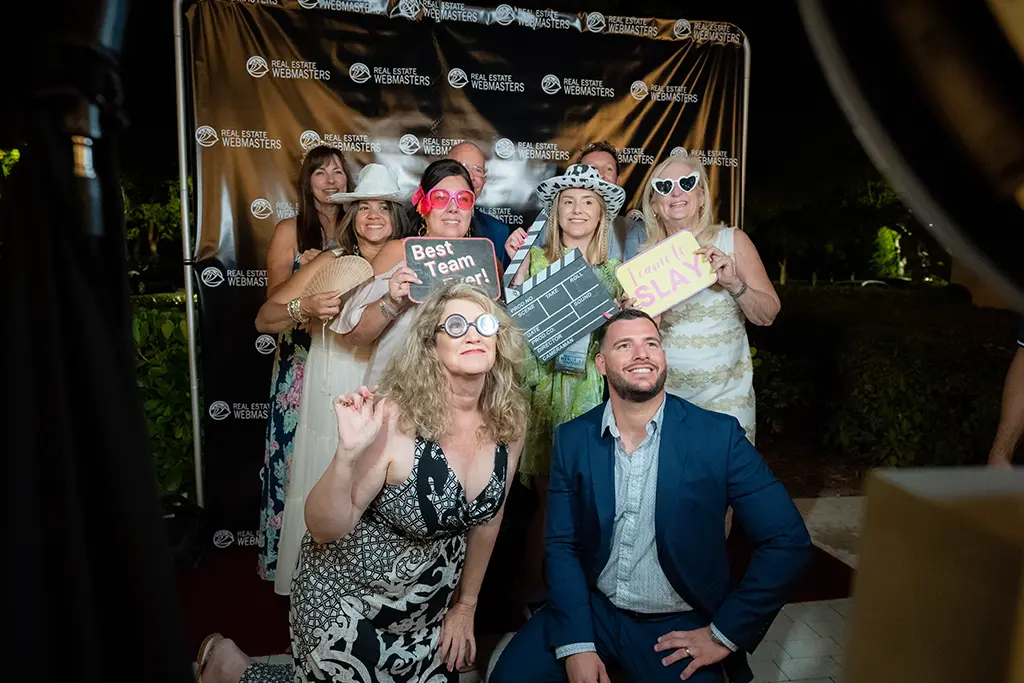 People having fun at a party using a photobooth to take silly group pictures