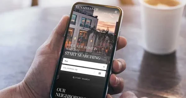 Hand holding cellphone showing a real estate website